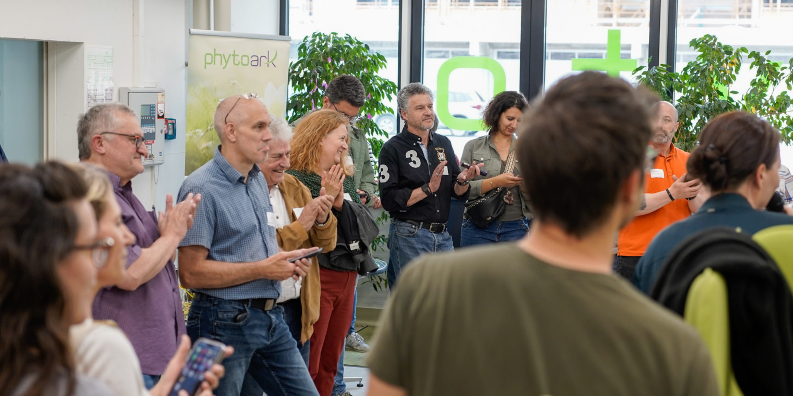 Participants écoutant des pitchs d'entreprises, dans le hall d'enttrée du bâtiment de PhytoaArk