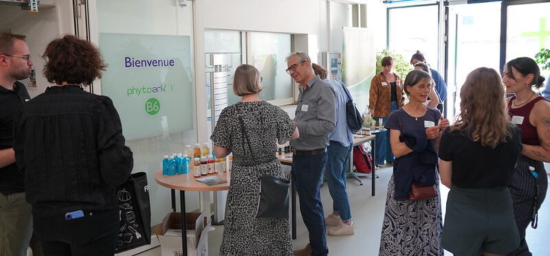 Groupe de personnes discutant dans le hall d'entrée du bâtiment de PhytoArk à Conthey