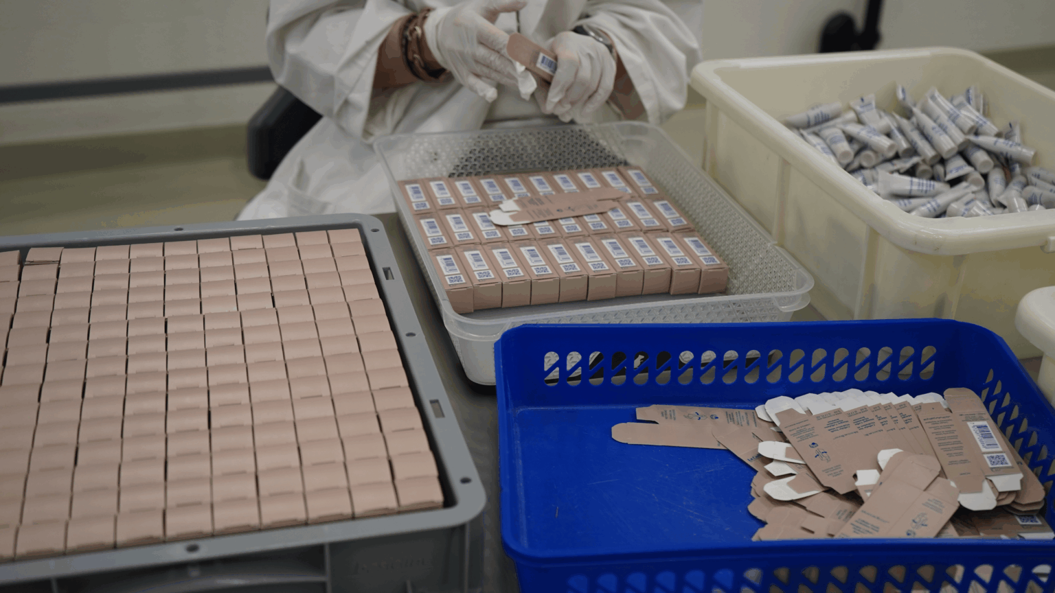 Conditionnement des petits tubes de produit cosmétique (échantillons) dans des cartons - atelier cosmétique de la FOVAHM à Conthey